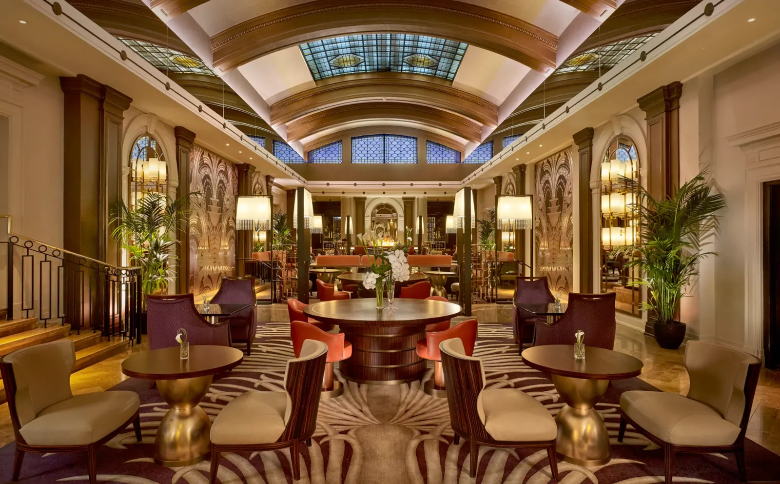 Grand hotel lounge with panelled walls, a barrel-vaulted ceiling and velvet armchairs