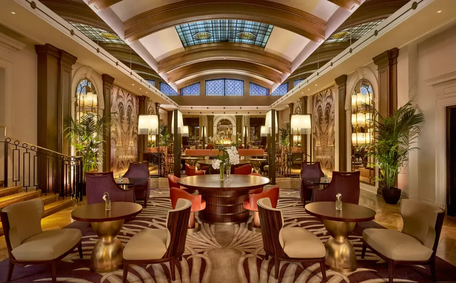 Grand hotel lounge with panelled walls, a barrel-vaulted ceiling and velvet armchairs