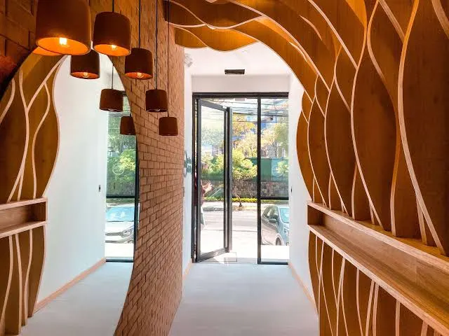 Corridor lined with sculpted, layered timber panelling around a doorway