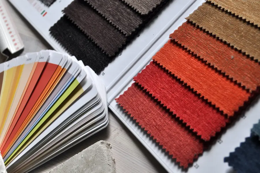 Fabric swatches in rust and charcoal next to a fan of colour samples