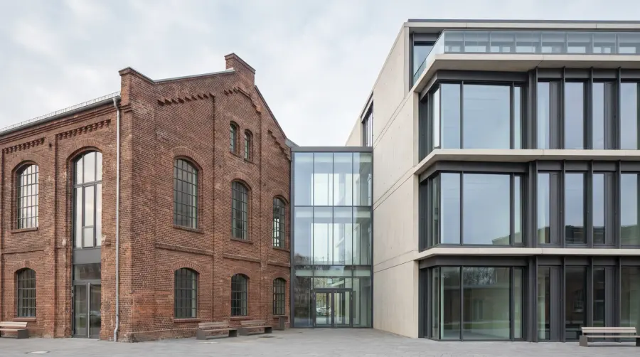 Single-storey extension with large windows next to an existing building