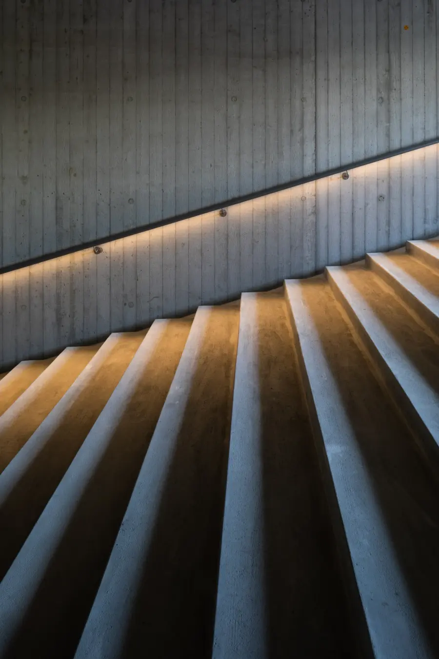 Concrete stairs with warm light along the wall