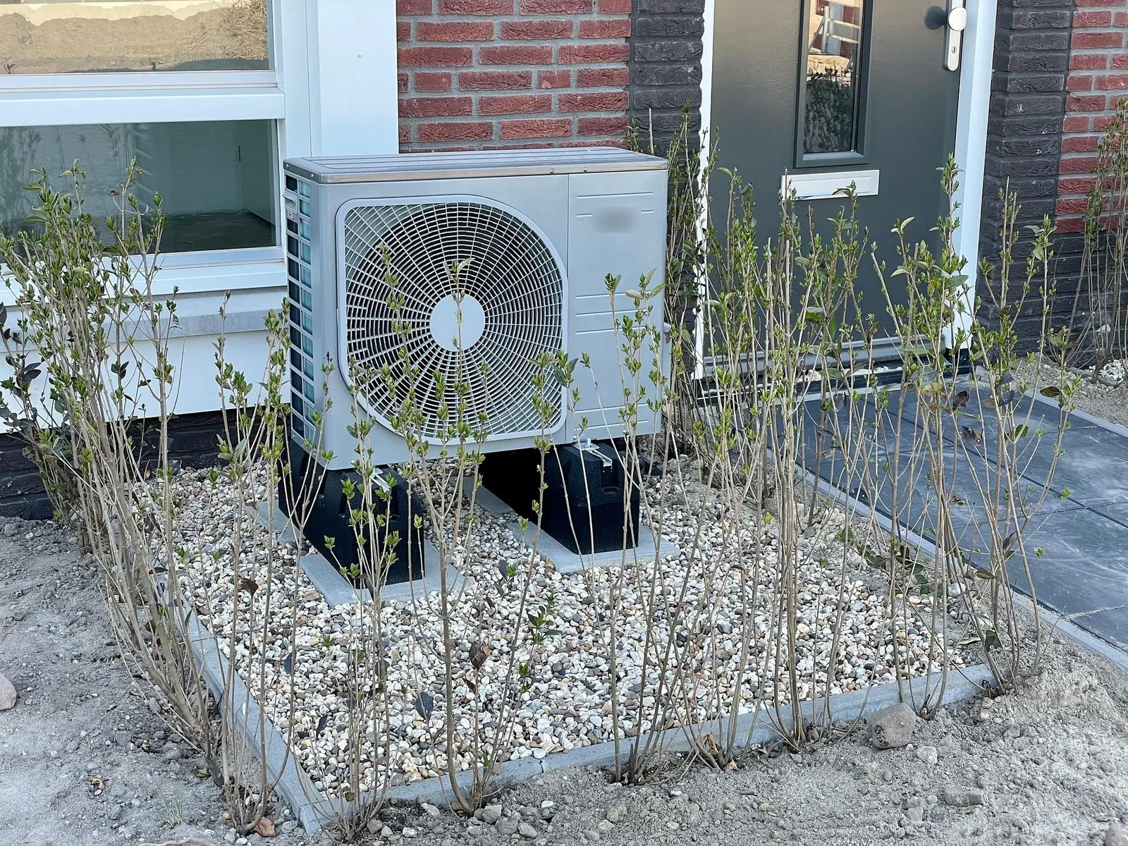 Outdoor unit of an air-to-water heat pump on a gravel base