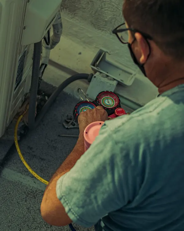 Technician reading pressure gauges in a plant room