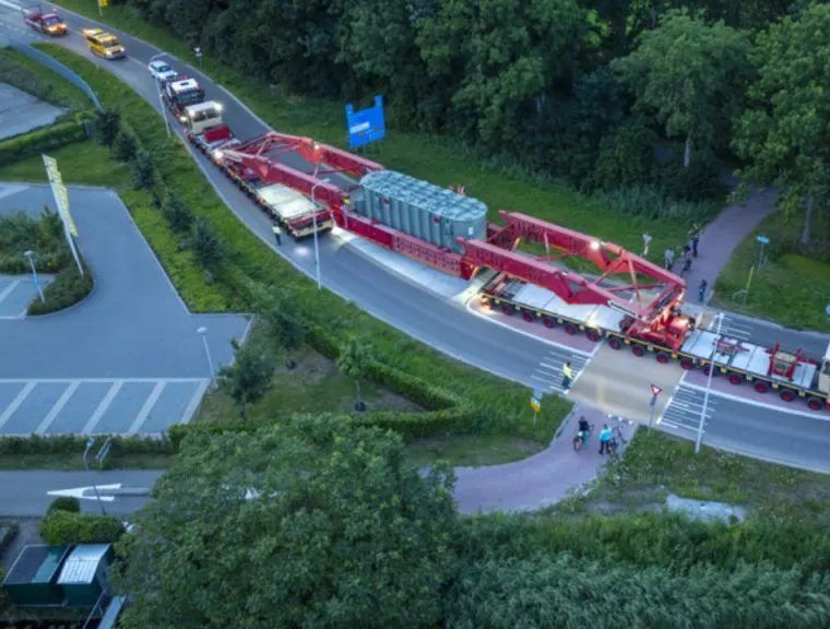 Aerial view of a heavy-haul convoy taking a road junction at dusk