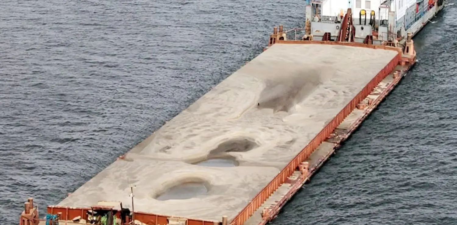 Loaded deck barge pushed across open water